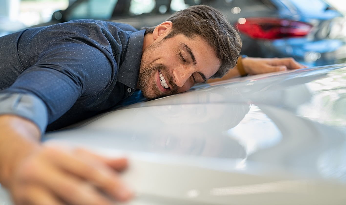 Hombre abrazando su coche